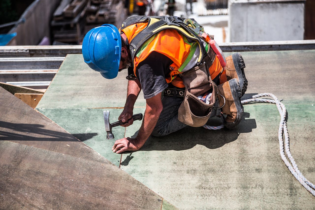 Crafting Captivating Headlines: Your awesome post title goes here A skilled construction worker in protective gear hammering a rooftop panel.